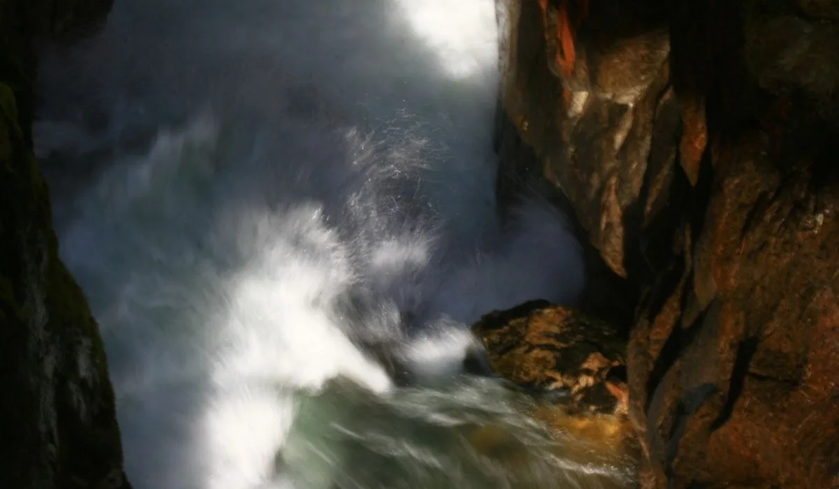 Torrent en mouvement entre les rochers, évoquant la force des émotions traversées en gestalt-thérapie